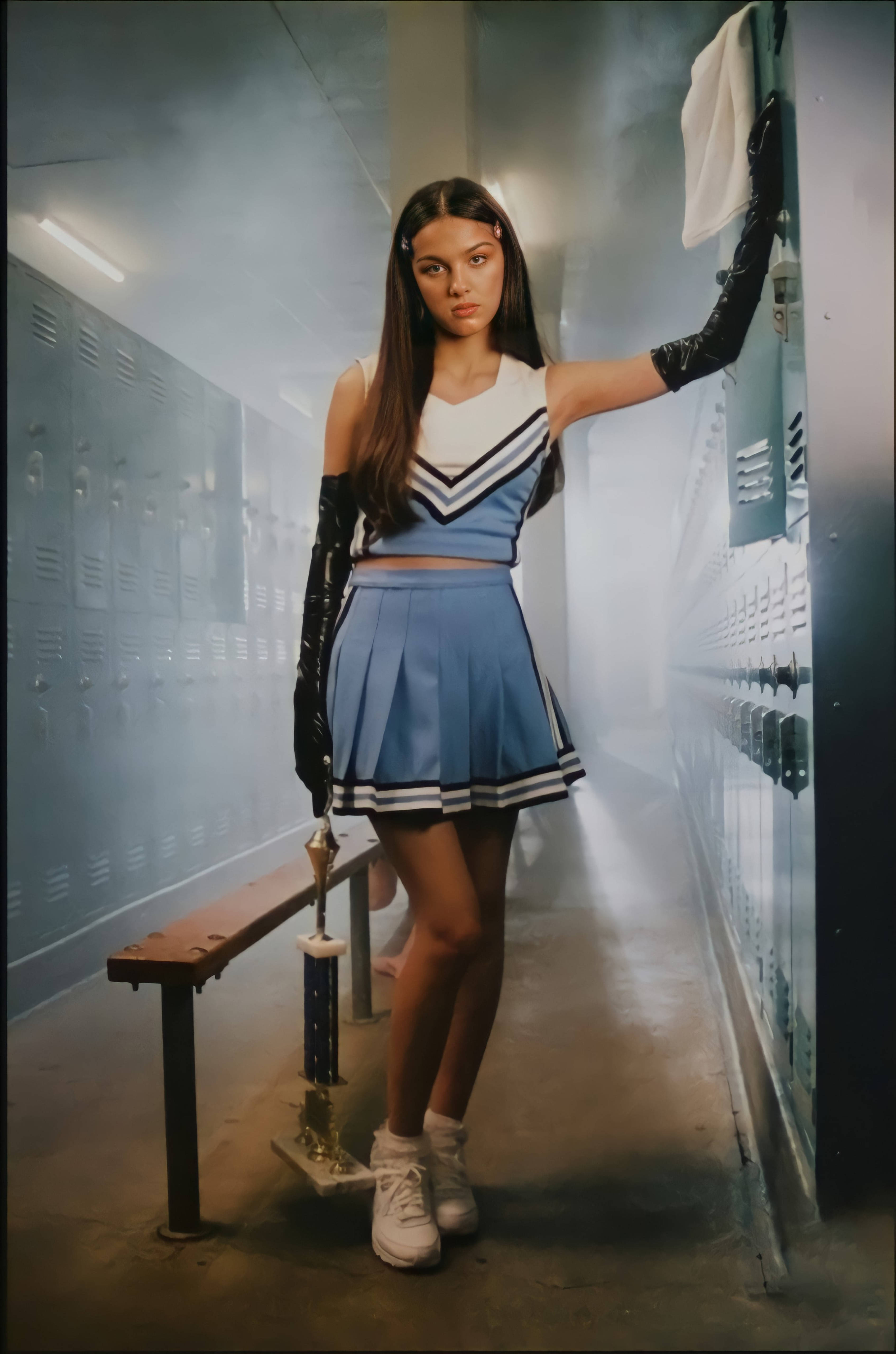 奧利維亞·羅德里戈在《Good 4 U》 壁紙 — 一位穿著藍白制服嘅啦啦隊員喺煙霧瀰漫嘅學校走廊自信咁企喺度，手拎住一個獎盃。