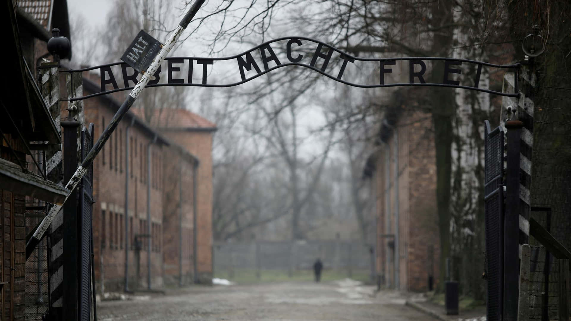 冬季的奧斯威辛集中營入口，帶有『Arbeit Macht Frei』標誌和磚砌建築。