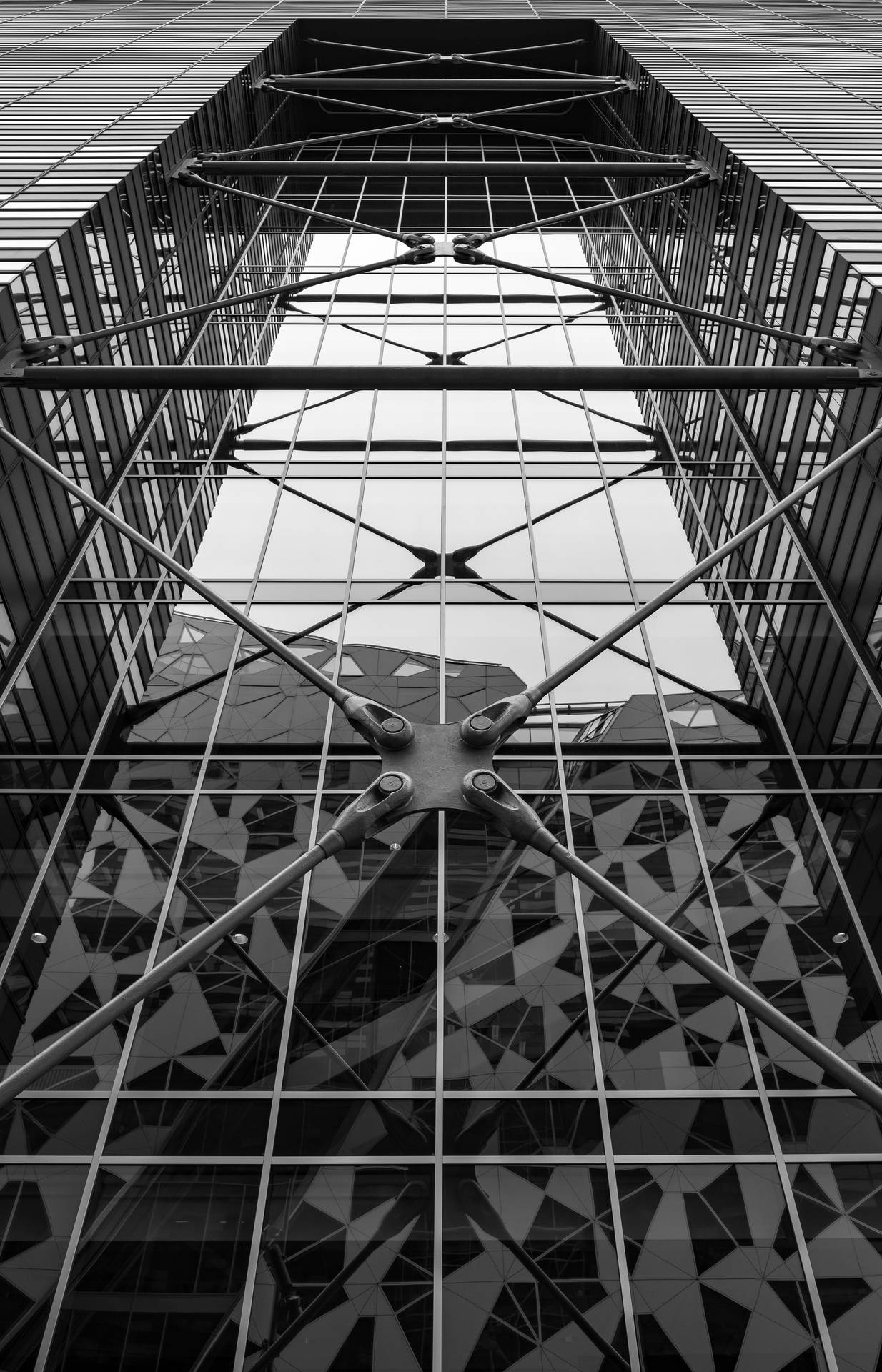黑白建築視角，展現玻璃摩天大樓的幾何圖案與反射。