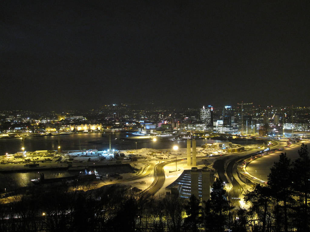 雪夜城市，燈光閃爍，道路蜿蜒。