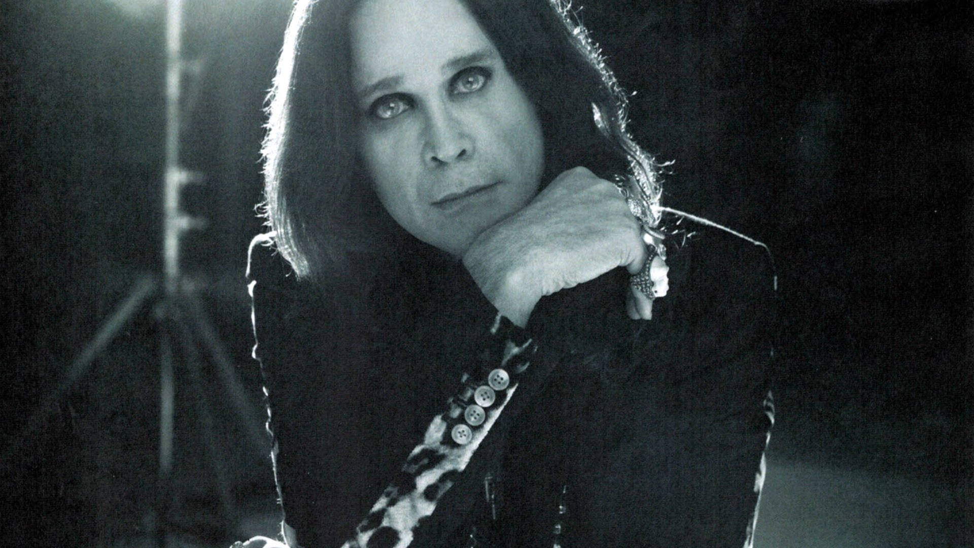 Ozzy Osbourne 的黑白肖像，下巴擱在手上。