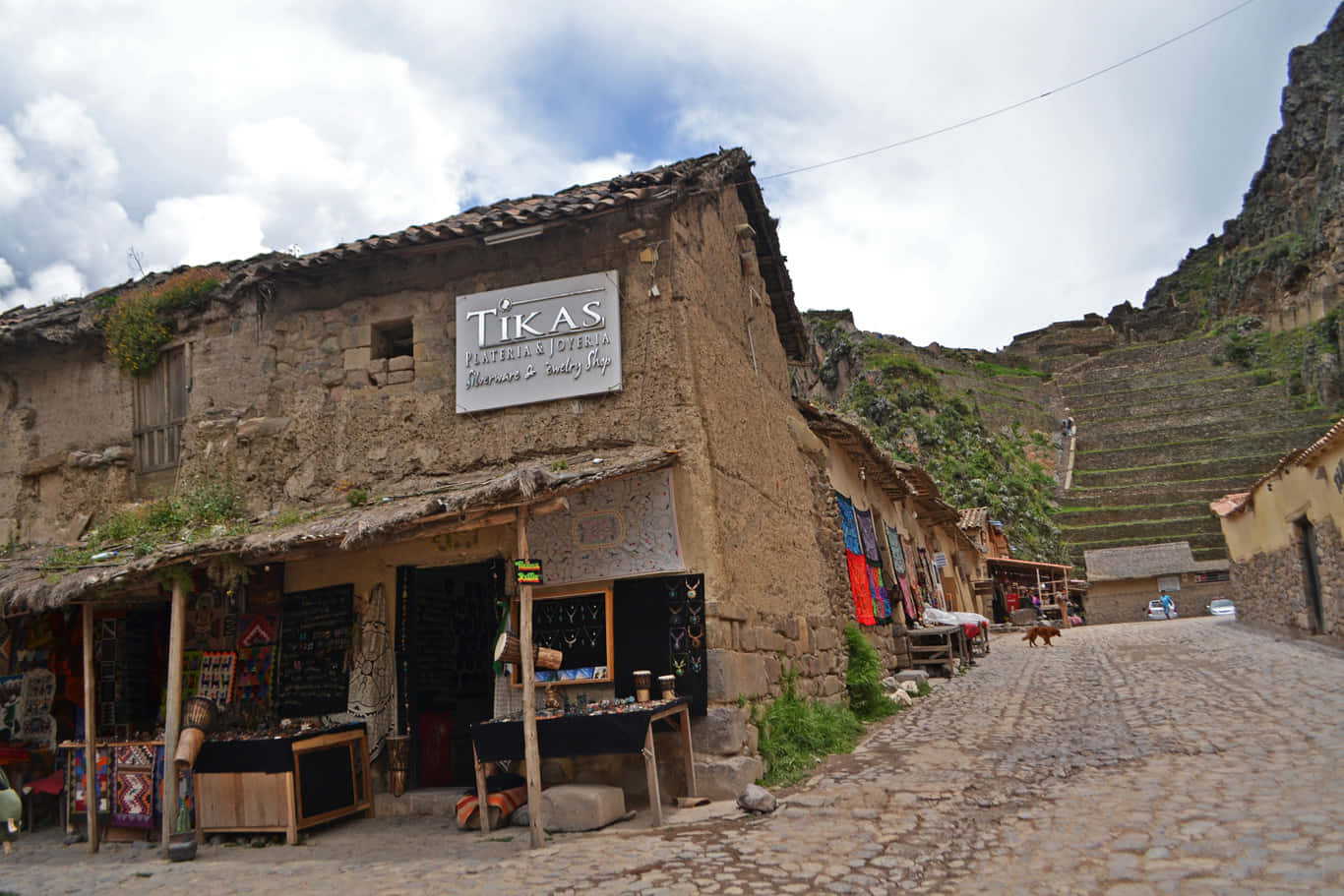 山村中的鵝卵石街道，有石頭建築和色彩繽紛的紡織品。