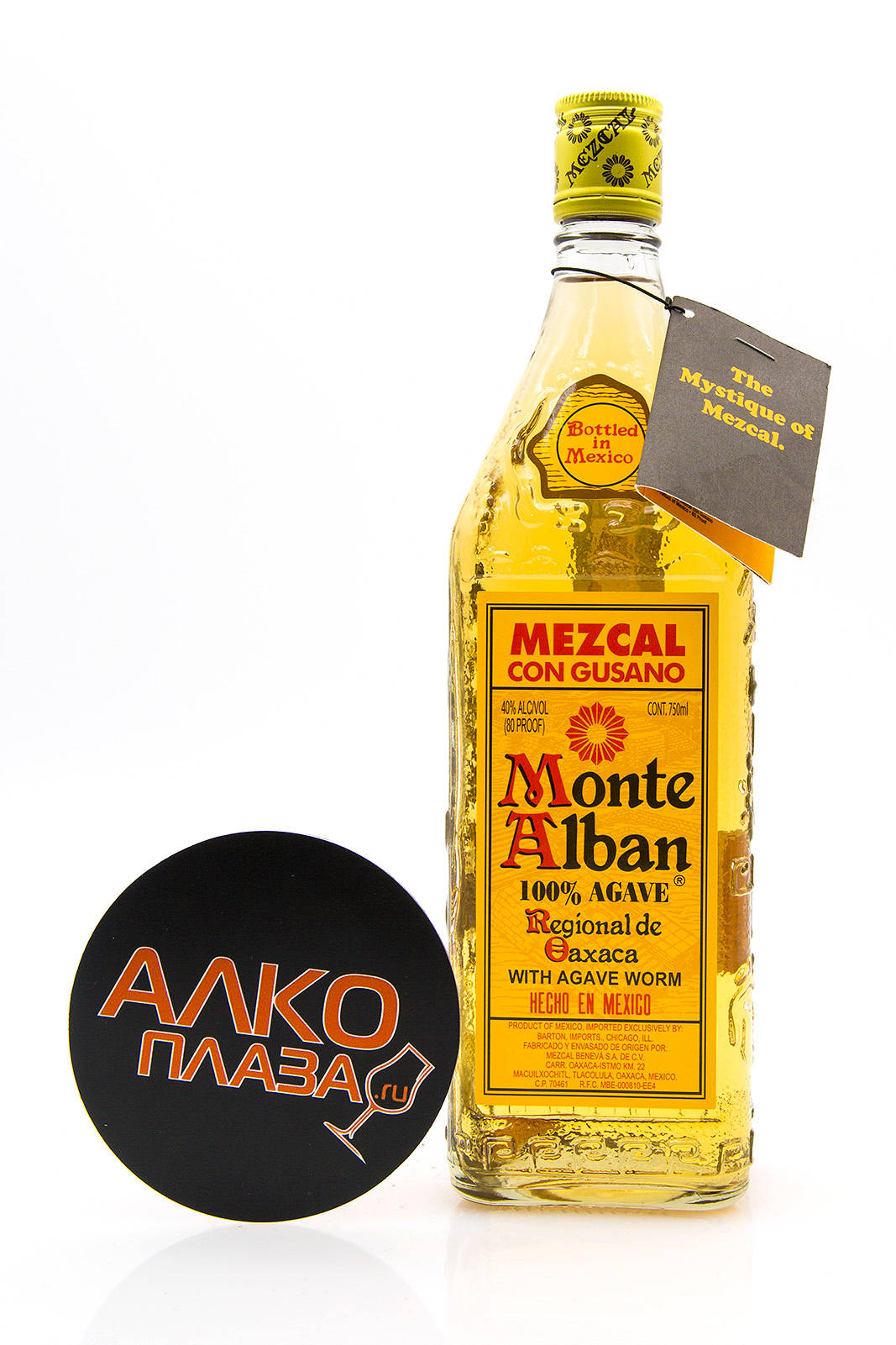 Monte Alban mezcal酒瓶帶有龍舌蘭蟲和帶有橙色西里爾文字的黑色杯墊。