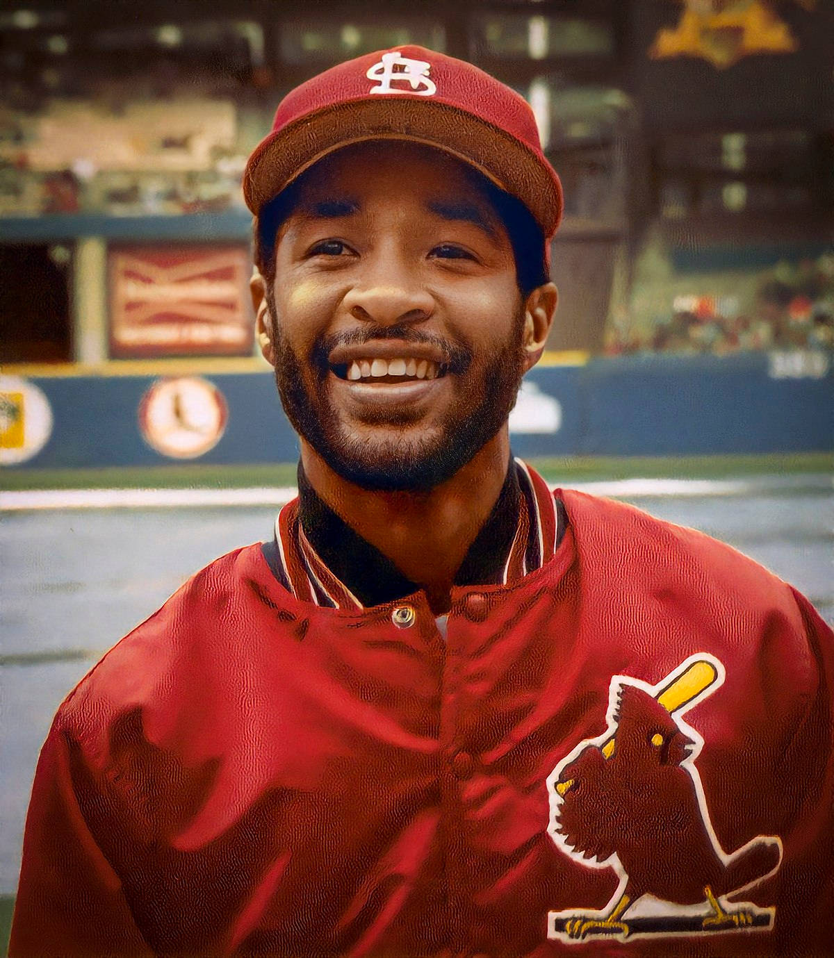 身穿紅色Cardinals球衣的棒球手在球場上燦爛微笑。