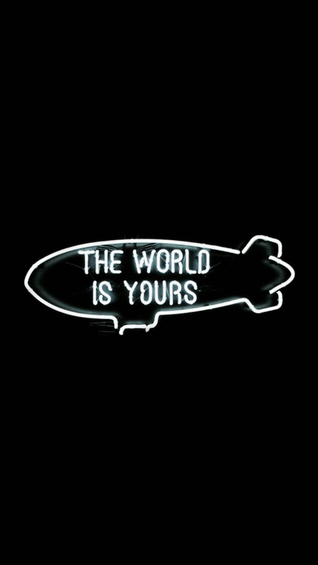 黑色背景上帶有「The World Is Yours」文字的飛船形霓虹燈牌。