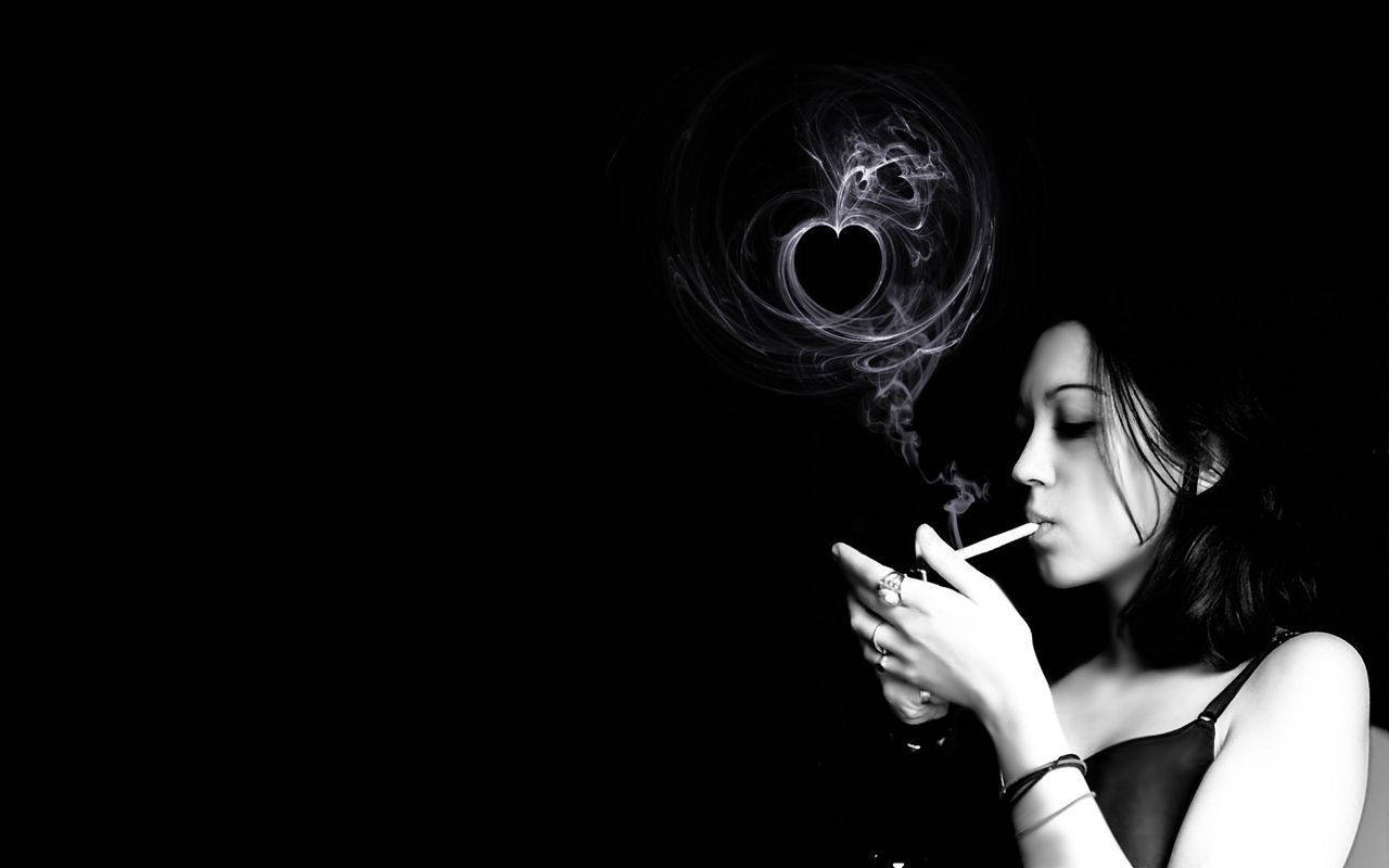 女性在黑白中呼出心形煙霧。