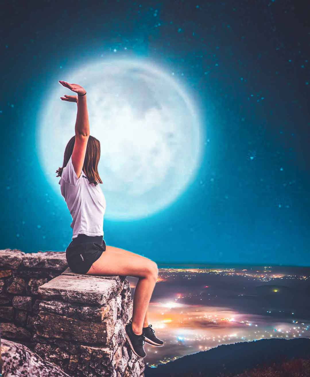 女子望月Picsart 壁紙 — 一名女子坐在石牆上，伸手朝向夜空中閃爍城市景觀上方一個巨大的發光月亮。