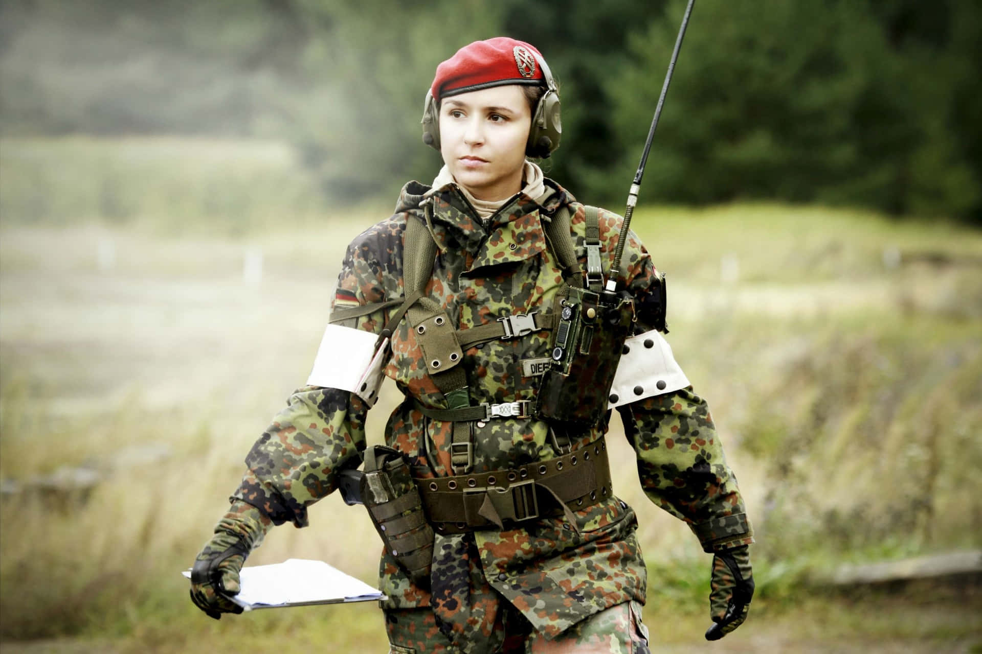 身穿迷彩服的女兵在戶外手持寫字板。
