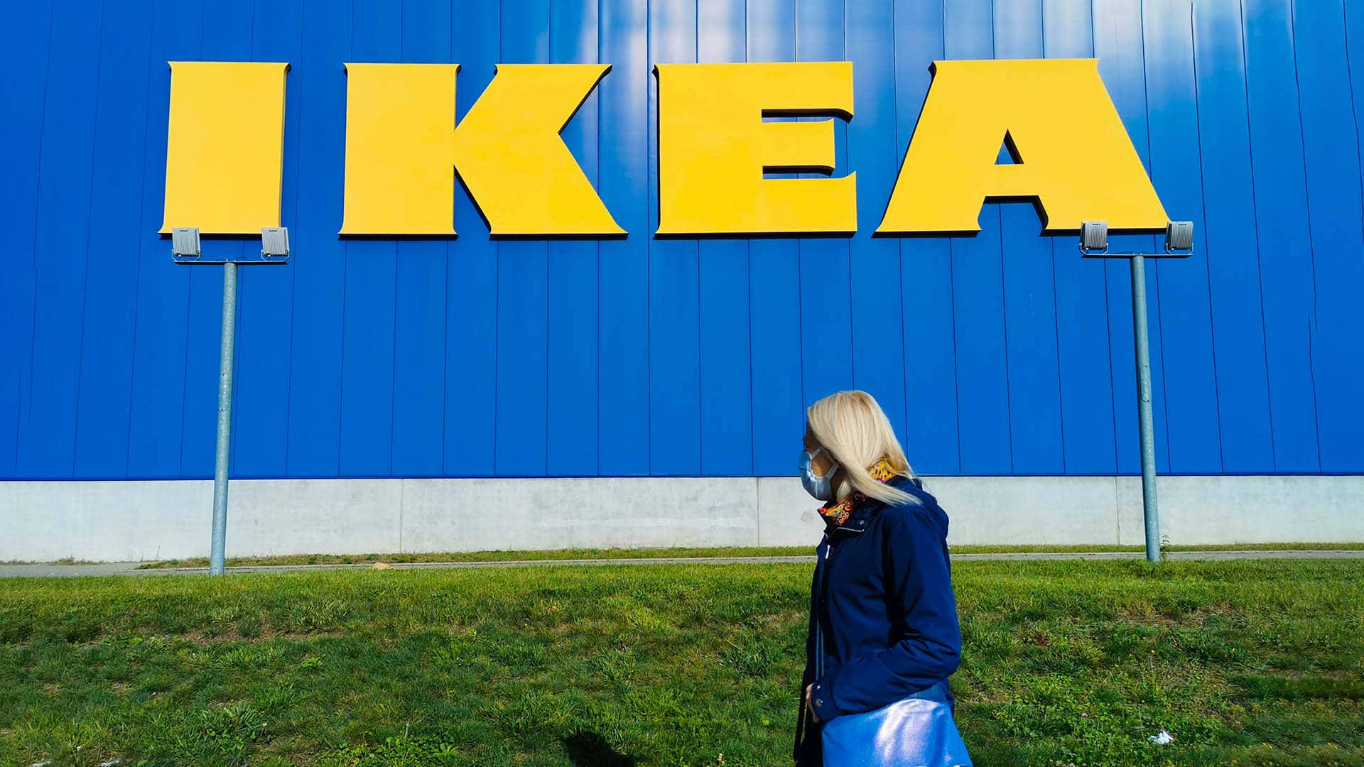 戴口罩的人走過IKEA商店標誌