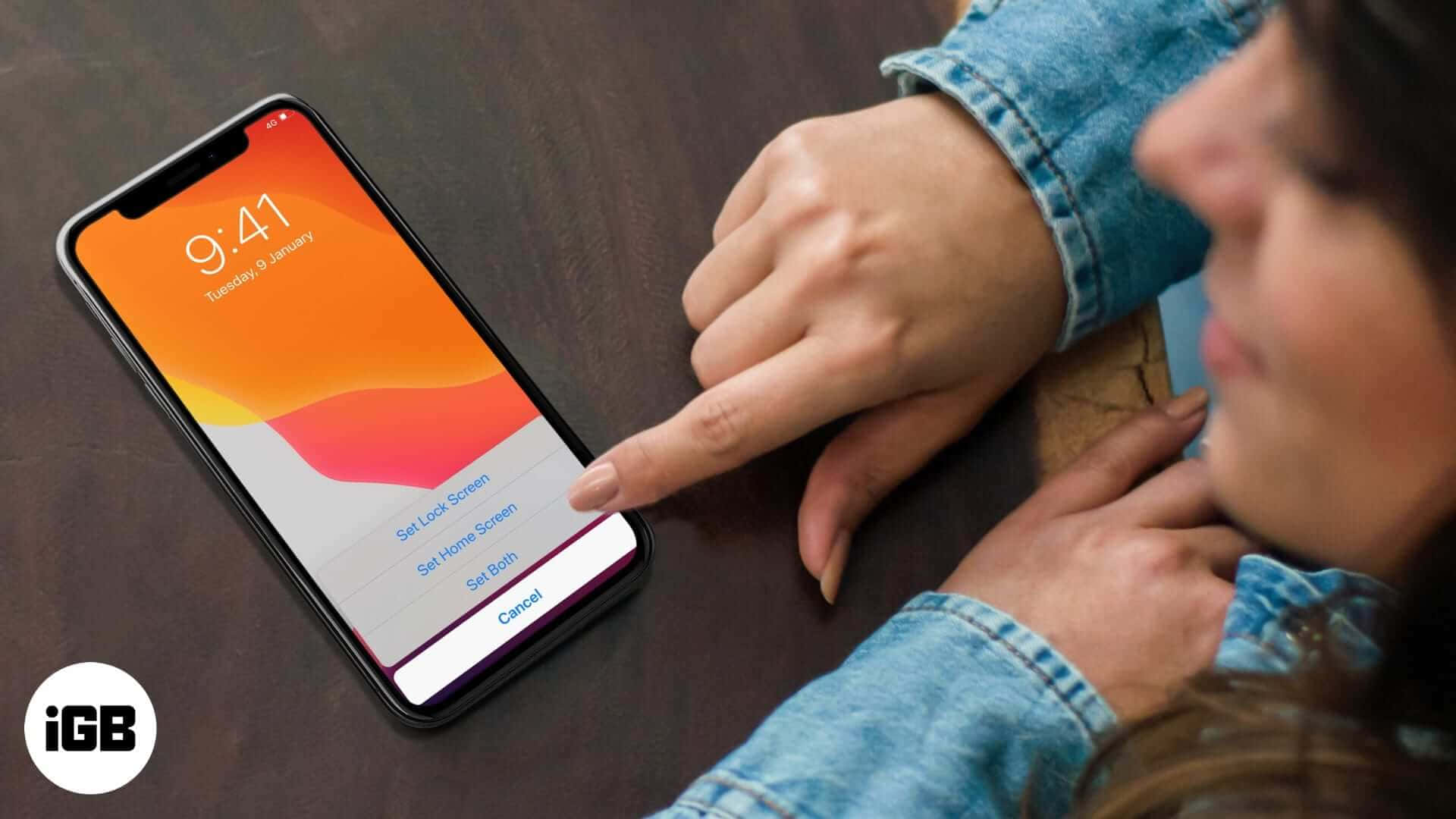 身穿牛仔布的人正在木桌上設定手機壁紙