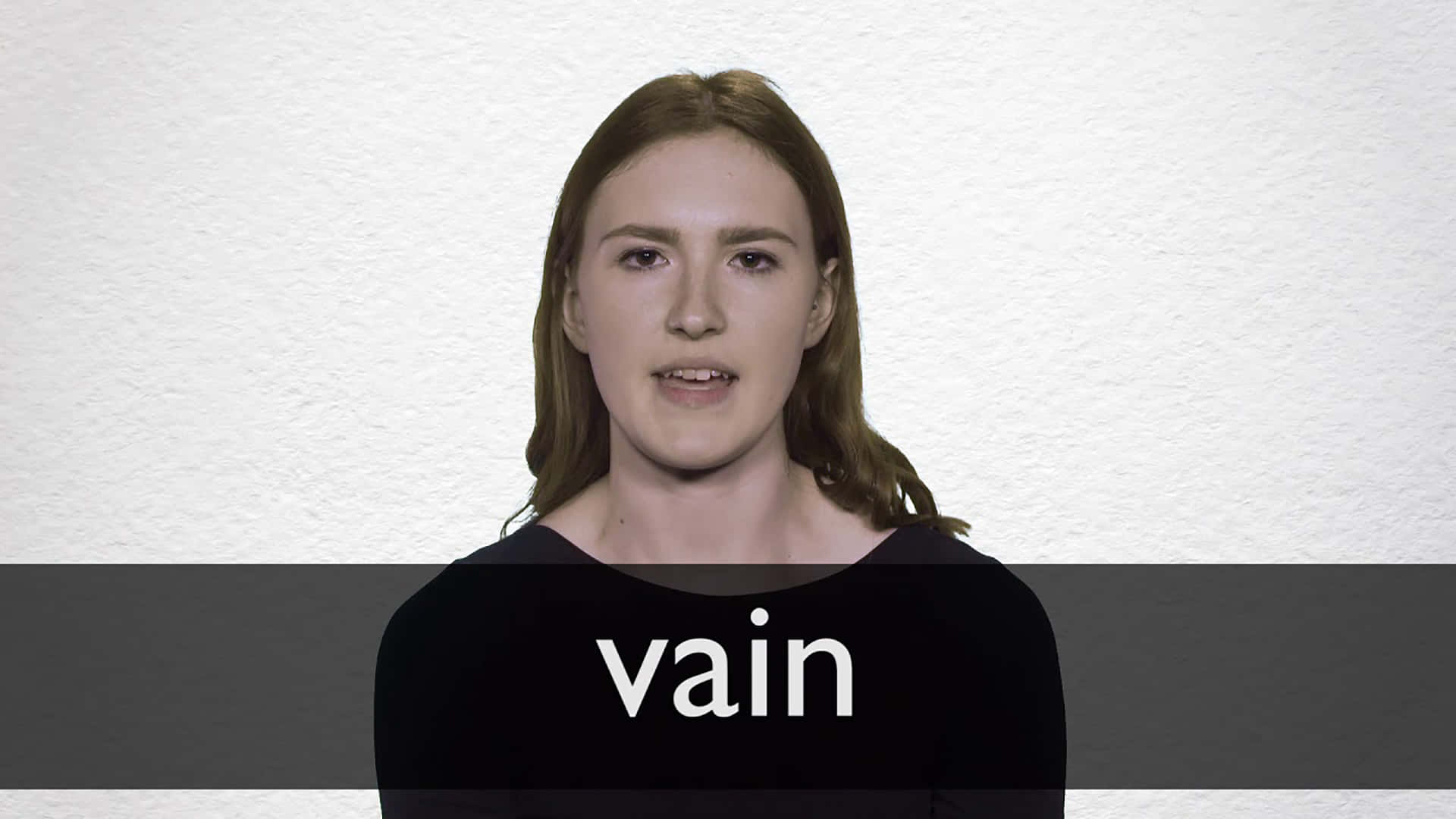 女性穿著黑色襯衫，胸前有 vain 字樣，背景為白色牆壁。