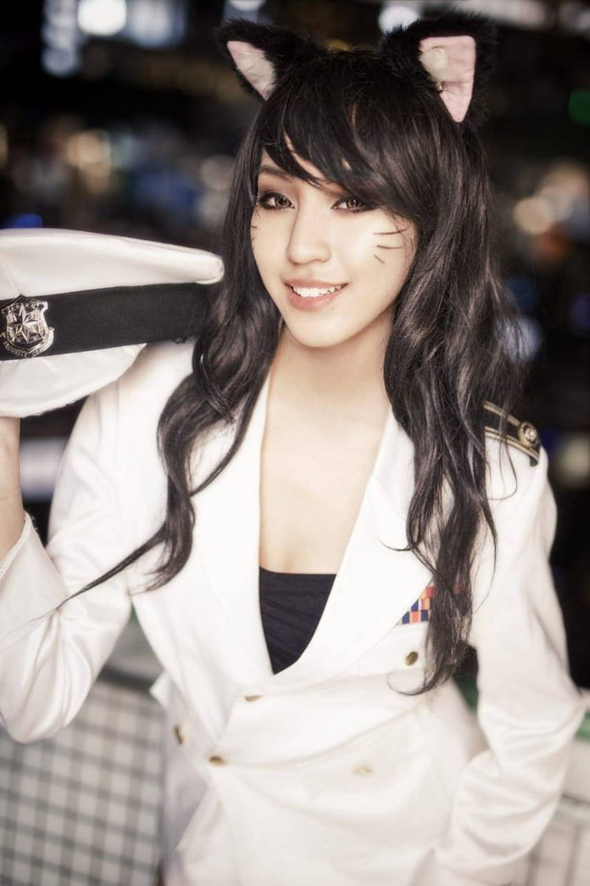 穿著白色水手cosplay、戴著貓耳的女性在城市的夜晚對著鏡頭微笑。