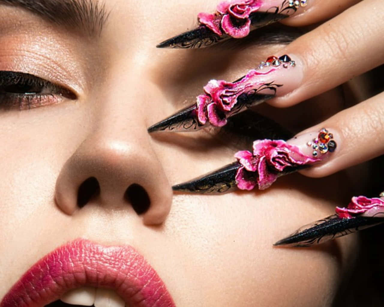 Cute Nails 桌布 壁紙 — 女性臉部特寫，帶有戲劇性的化妝和華麗的粉紅色花卉指甲，部分遮蓋了她的眼睛。