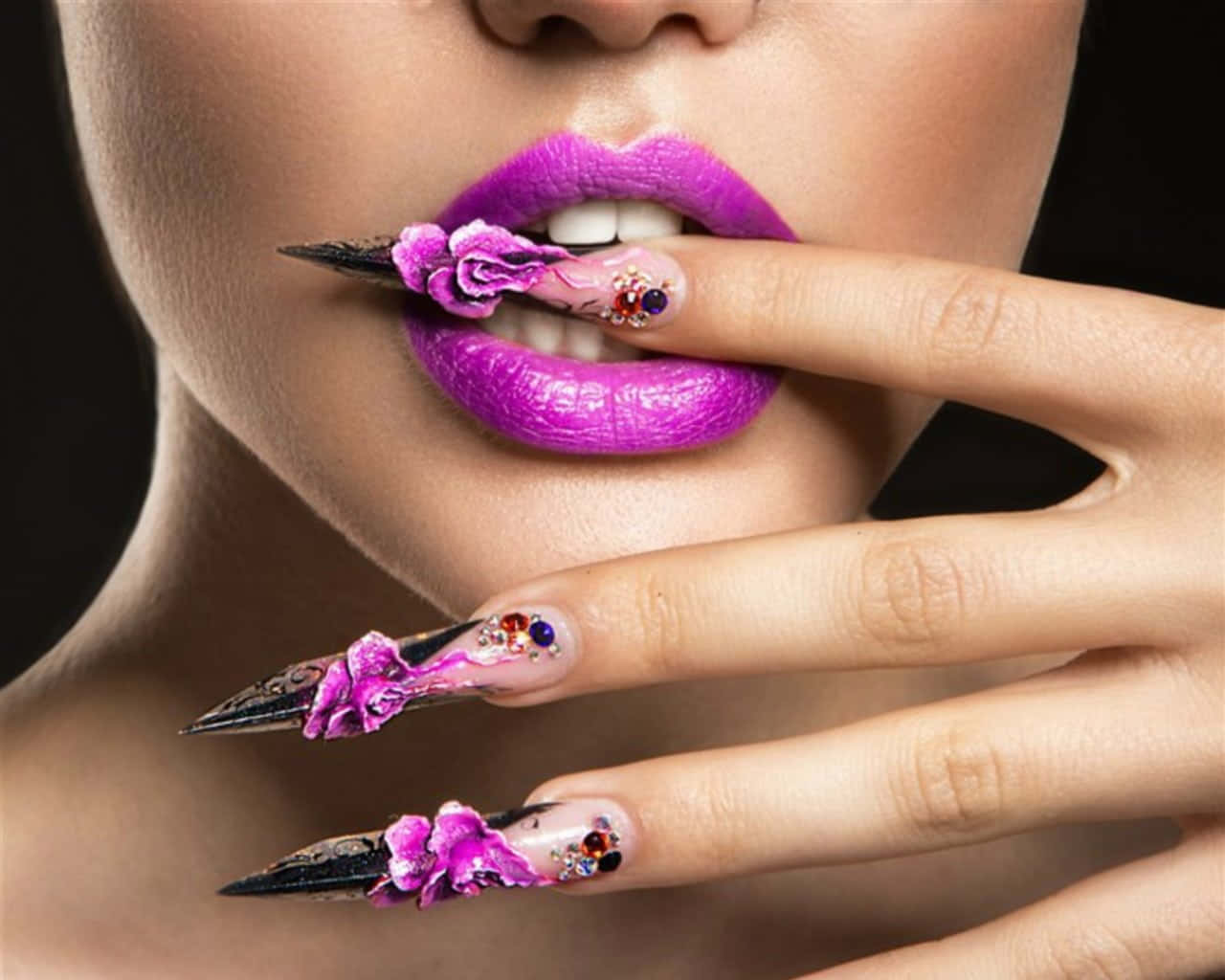 Cute Nails 桌布 壁紙 — 女性臉部特寫，帶有鮮豔紫色嘴唇和華麗粉紅色花卉指甲，遮住嘴巴。
