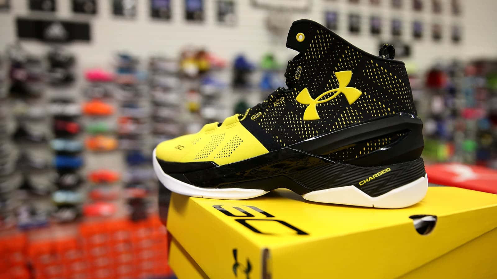 運動鞋店中，黑色和黃色 Under Armour 籃球鞋放在其黃色鞋盒上。