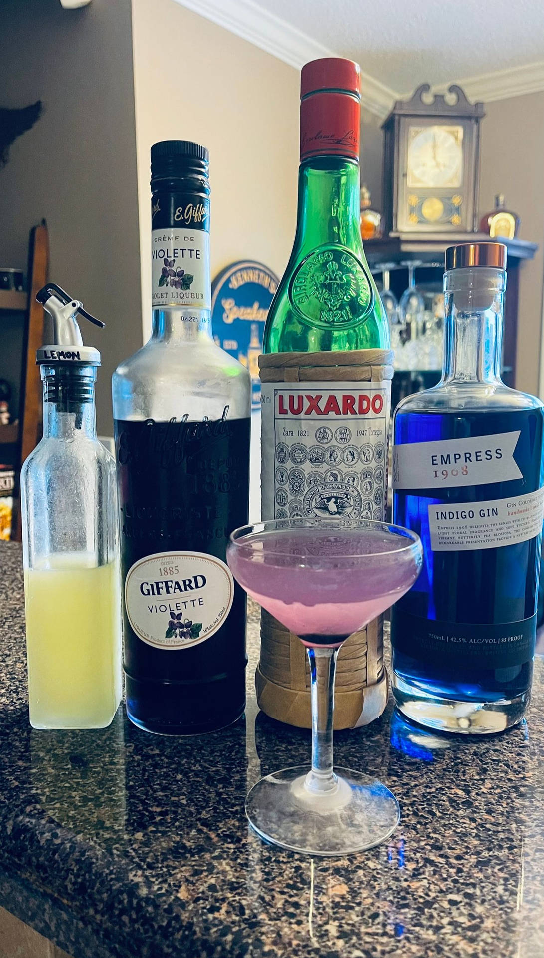 廚房檯面上的紫色雞尾酒，配以氈酒和紫羅蘭利口酒瓶。