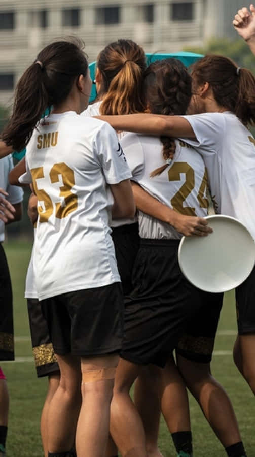 女運動員擁抱 Android Ultimate Frisbee 背景 壁紙 — 一群身穿白色球衣的女子終極飛盤選手在日間比賽中緊密地聚集在草地上。