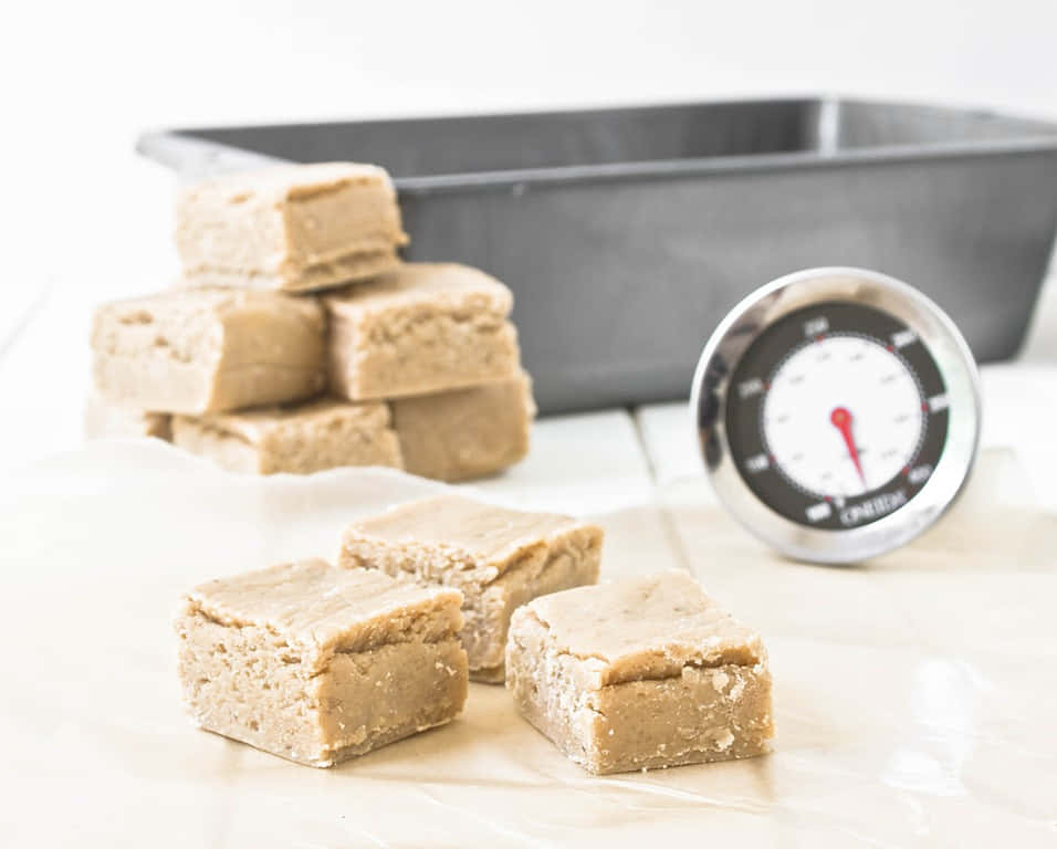 Penuche Fudge 桌布 壁紙 — 奶油花生醬軟糖方塊放在烘焙紙上，旁邊有糖果溫度計和烤盤。