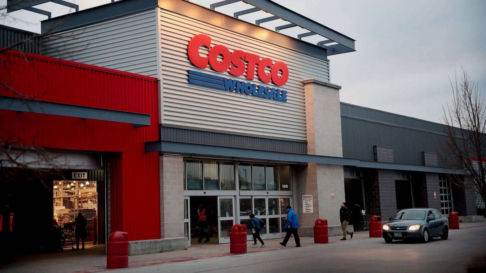 Costco商店入口，購物者和一輛車，黃昏時分。