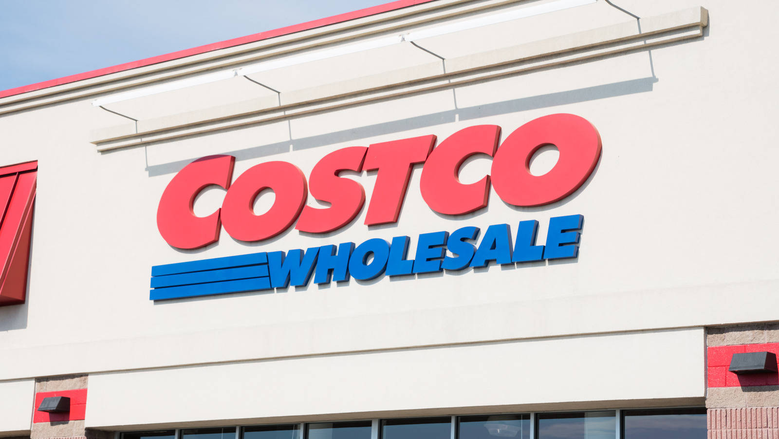 米色建築物上的 Costco Wholesale 商店招牌，帶有紅色和藍色字體。