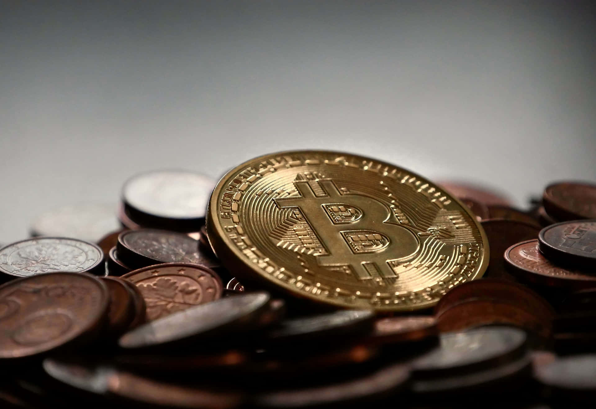 一枚金色比特幣硬幣被傳統硬幣包圍。