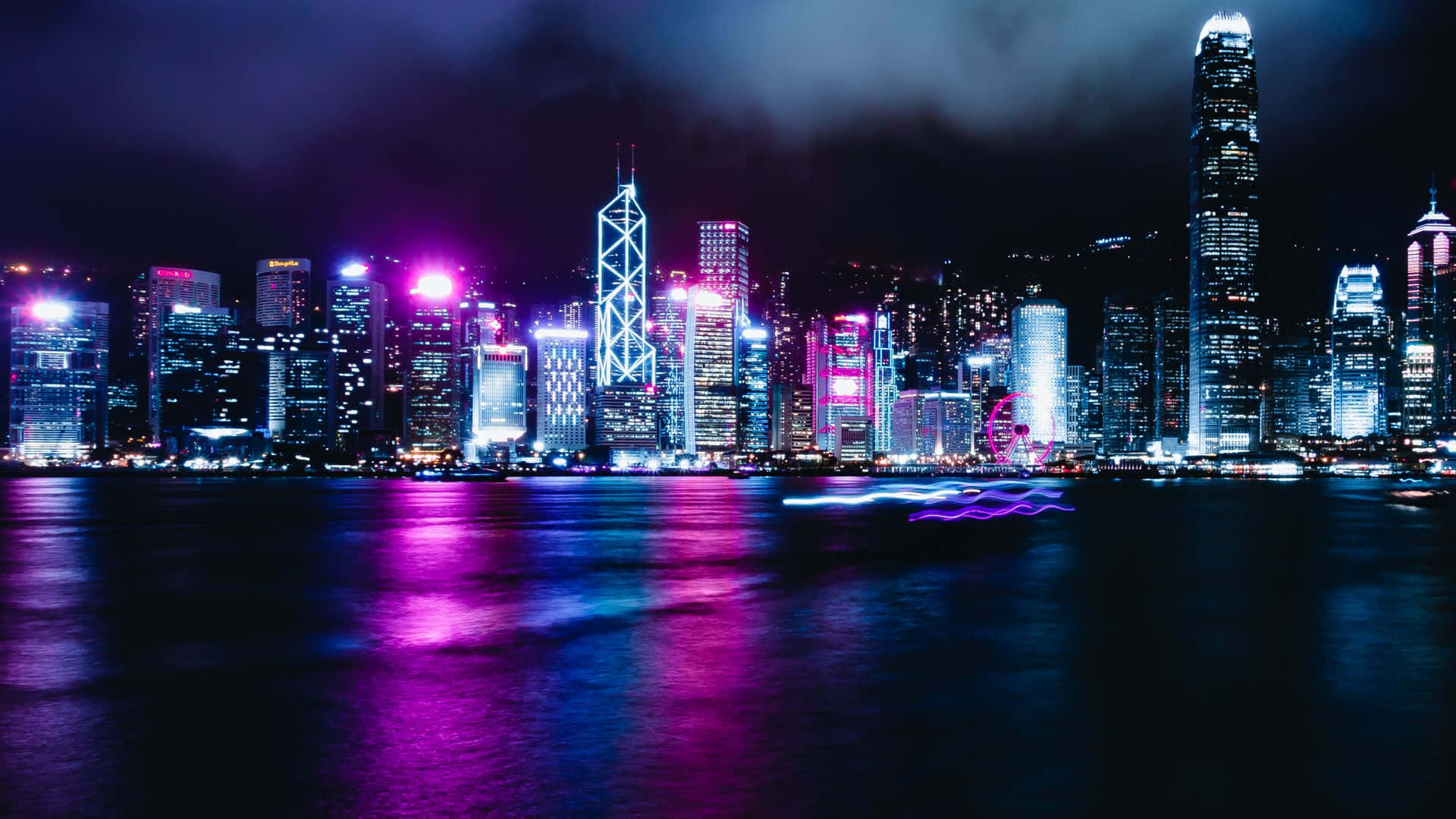 霓虹燈閃爍的摩天大樓在夜晚繁忙的城市水面上反射。