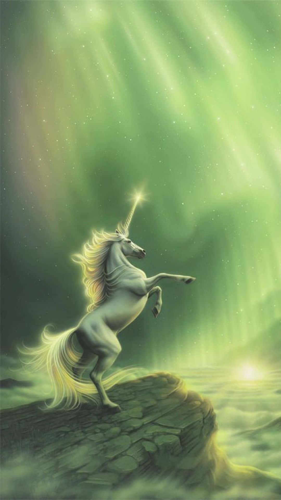 威嚴綠色獨角獸圖像 壁紙 — 一匹雄偉的白色獨角獸在岩石懸崖上驕傲地揚起，下方是充滿活力的綠色北極光，散發著天國的光芒。
