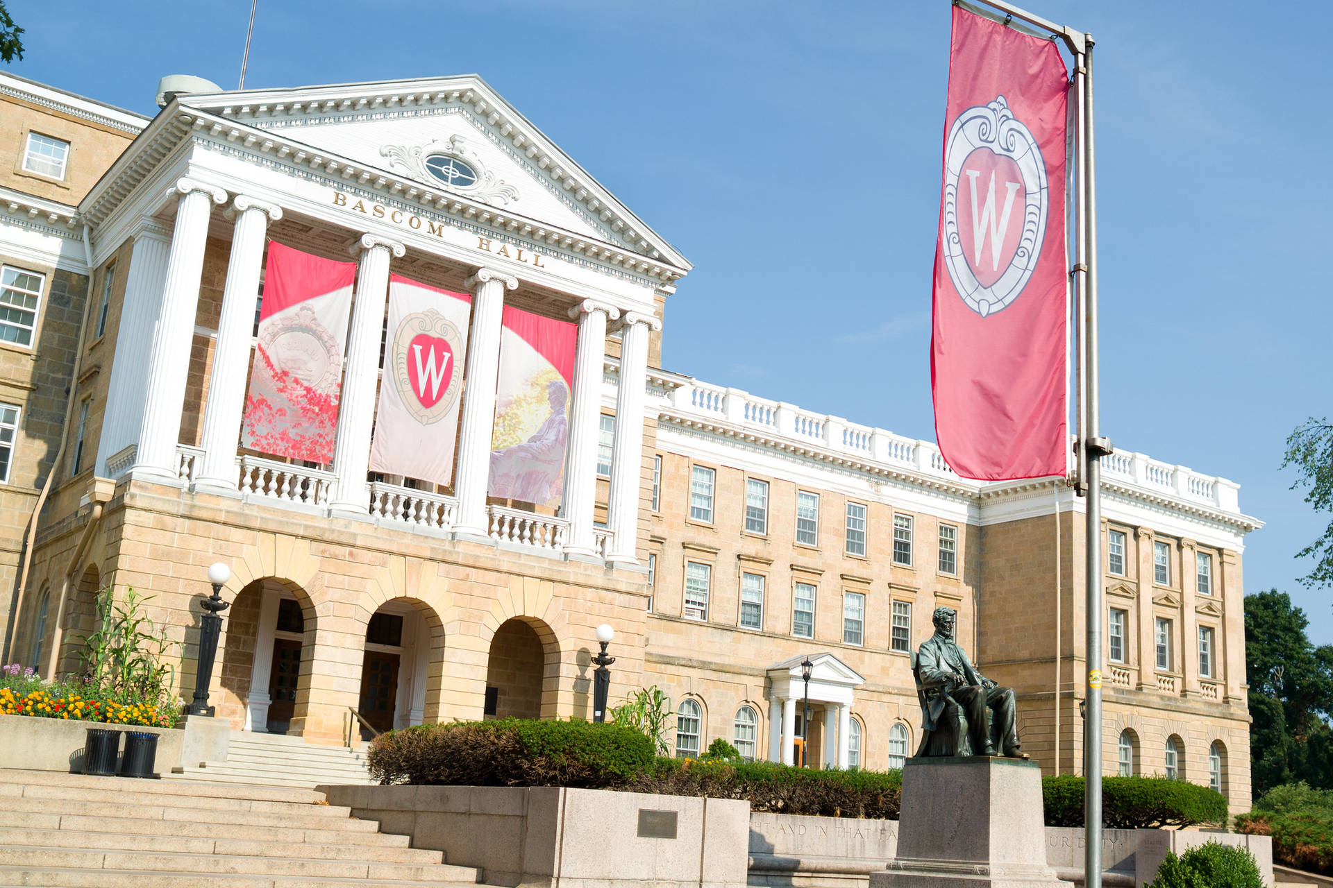 Bascom Hall大學建築，前方有紅色橫幅和雕像。