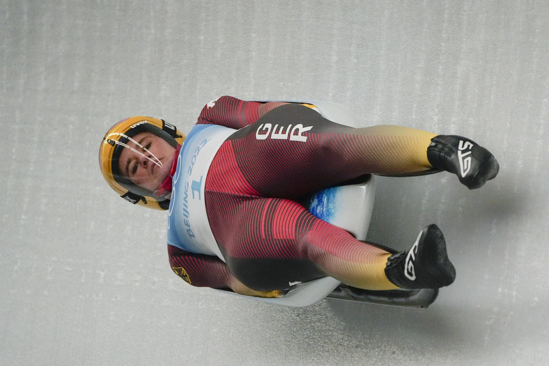 雪橇運動員在冰道上穿著冬季奧運制服競賽