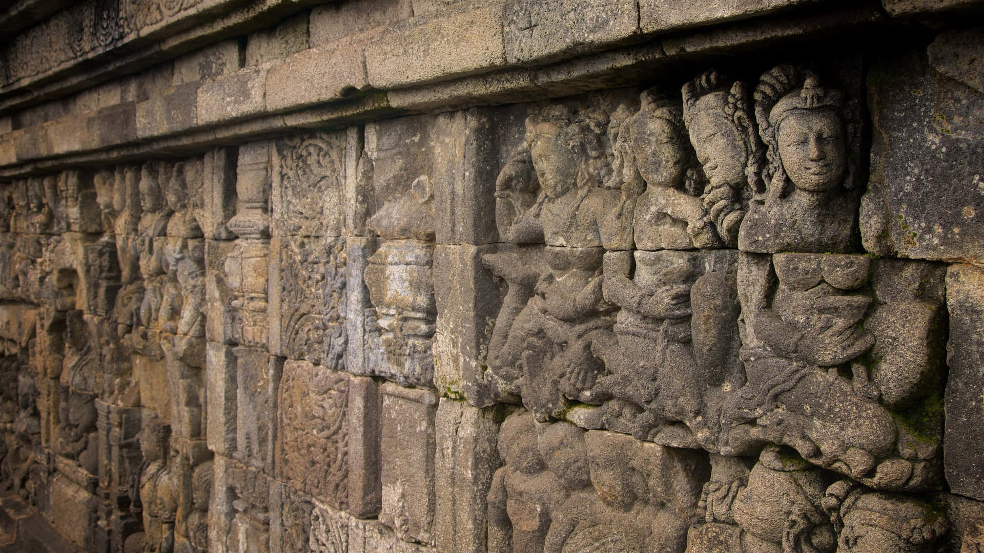婆羅浮屠寺的雕塑與古雅之美 壁紙 — 古代石雕在風化的寺廟牆上以精細浮雕描繪寧靜的人物。