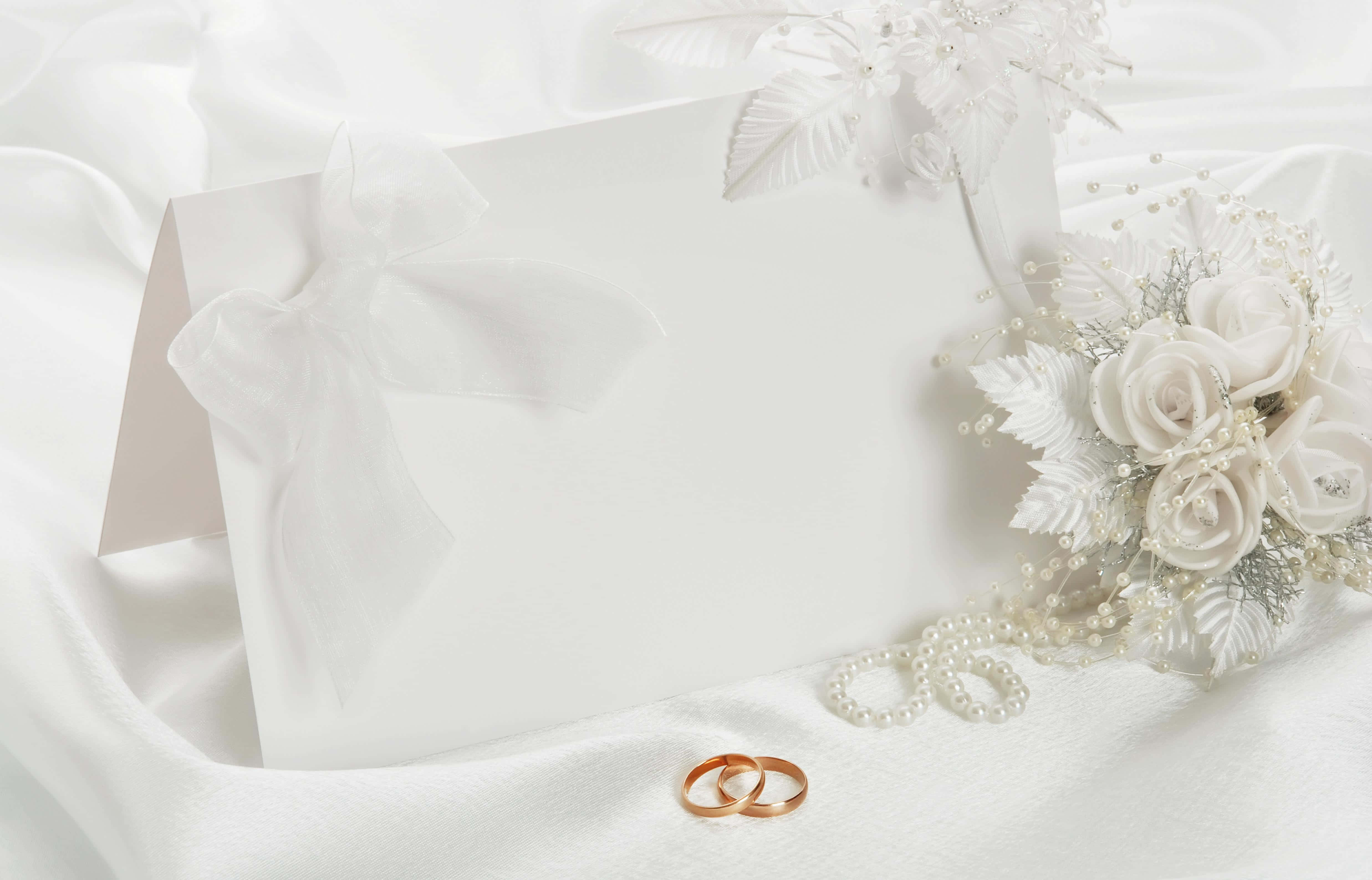 婚禮邀請卡，配有結婚戒指與花朵 壁紙