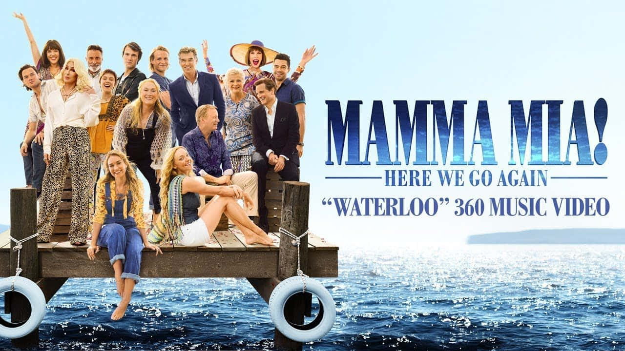 Mamma Mia 桌布 壁紙 — 《媽媽咪呀！開心再嚟》嘅演員喺晴朗天空下，喺閃爍藍色海水上嘅木碼頭上開心擺甫士。