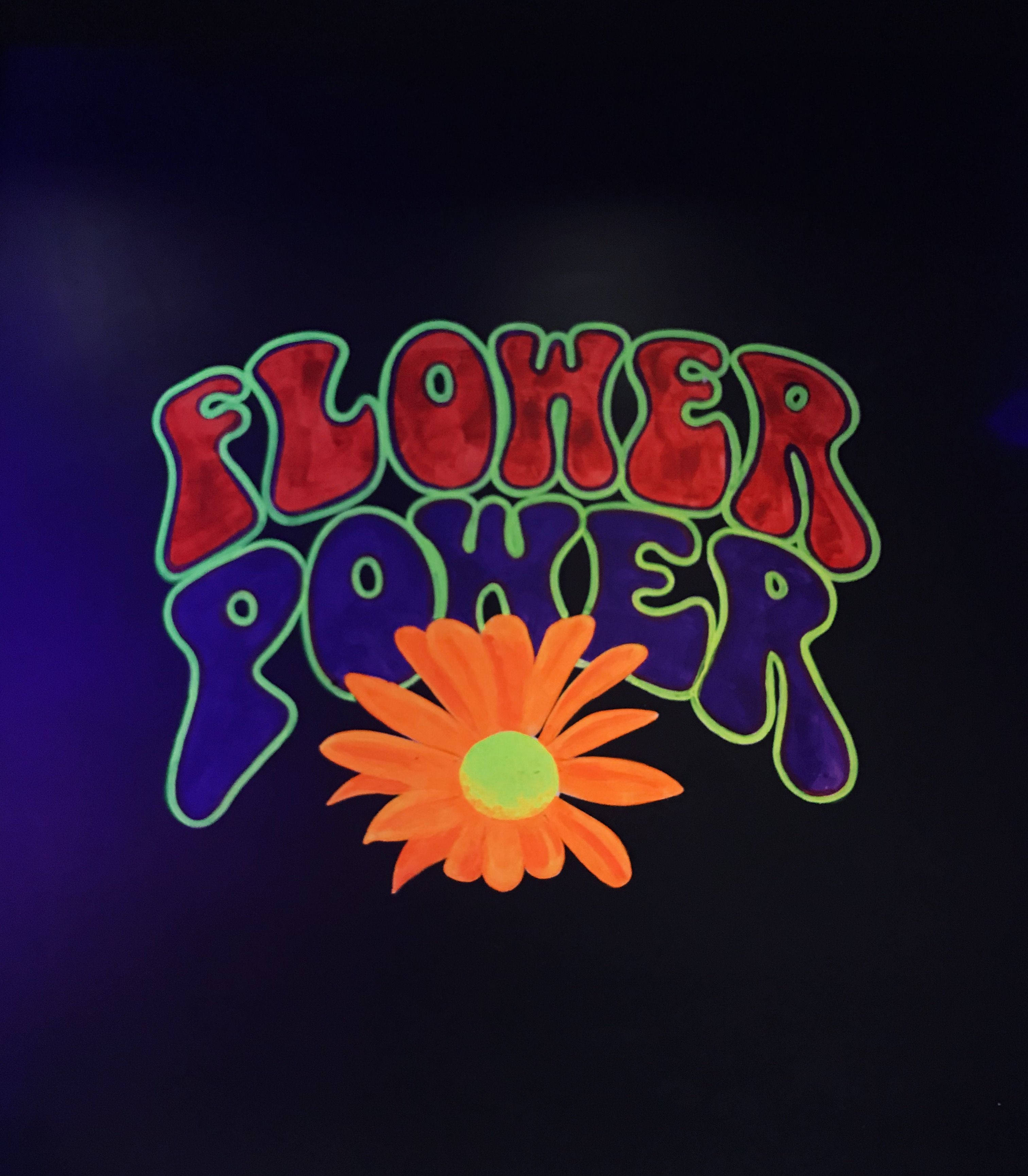 嬉皮士「花的力量」標語插畫 壁紙 — 鮮豔的霓虹燈 'Flower Power' 文字，帶有發光的橙色雛菊，背景為深紫色。