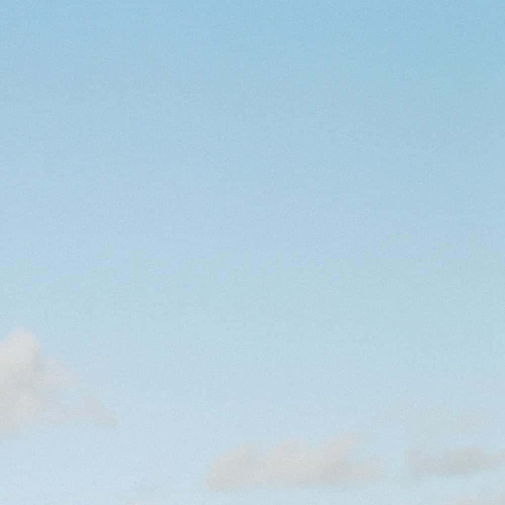 寧靜的粉藍色天空，柔軟的白雲輕輕飄動。