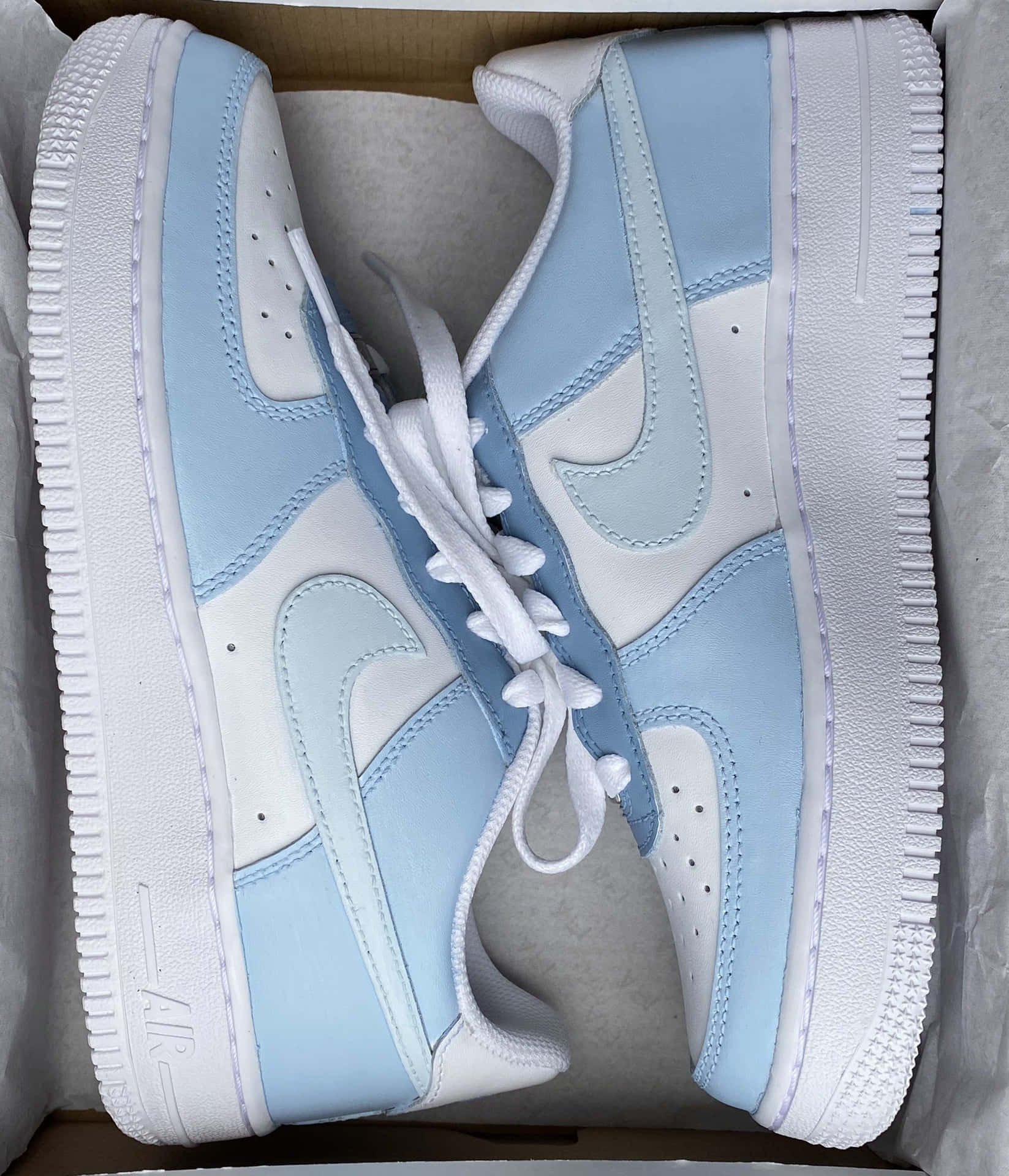 淺藍色和白色的Nike Air Force 1運動鞋，放在原裝盒內。