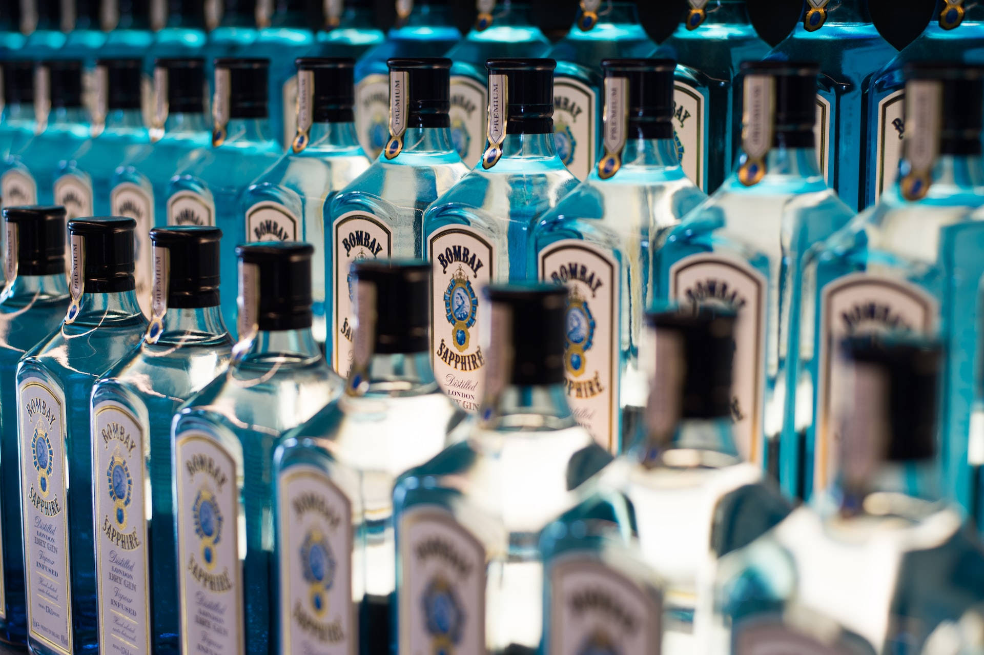 架上一排排藍色 Bombay Sapphire 氈酒瓶，景深較淺。