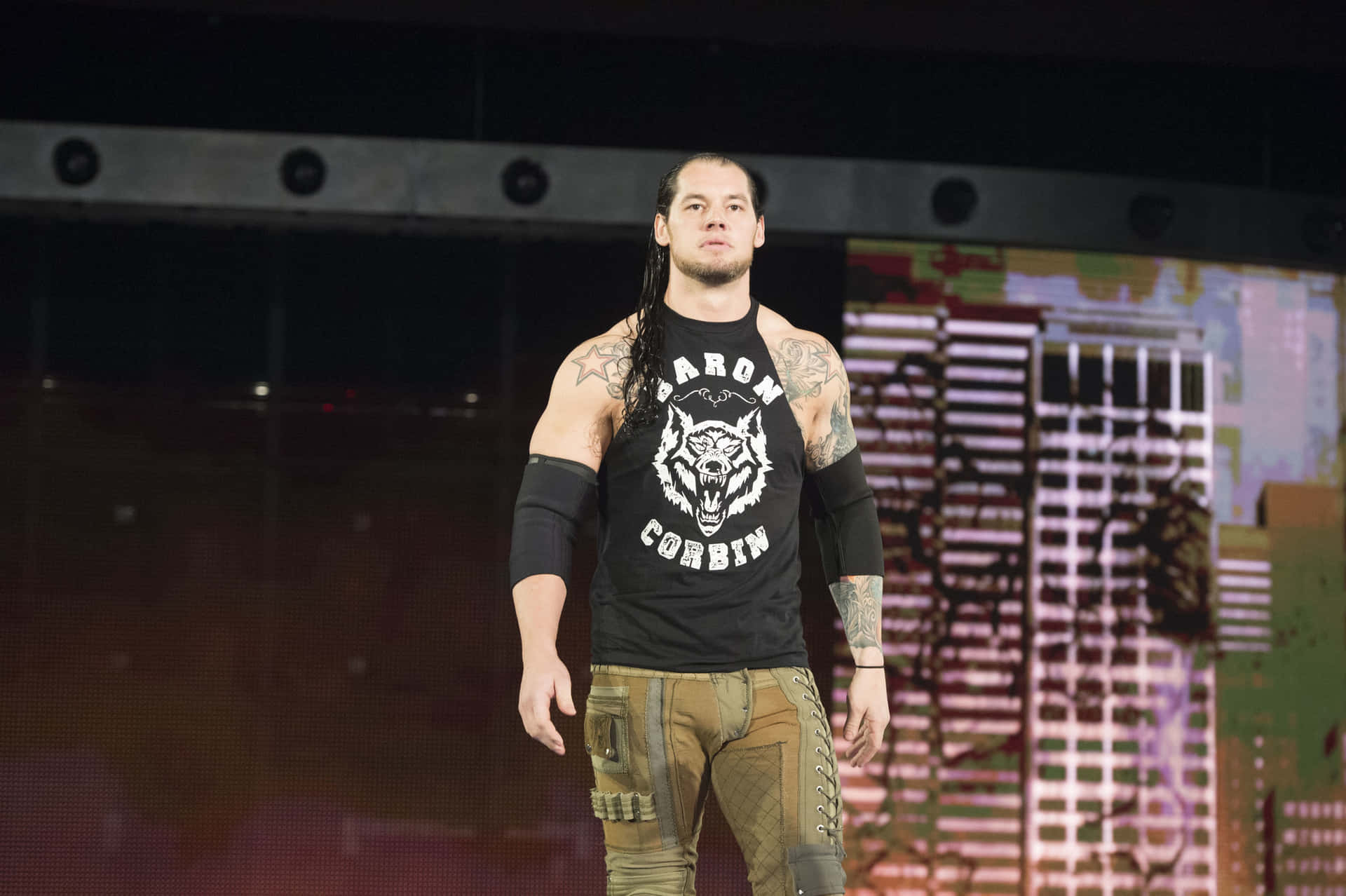 摔角手 Baron Corbin 在舞台上穿著黑色 T 恤和工裝褲。