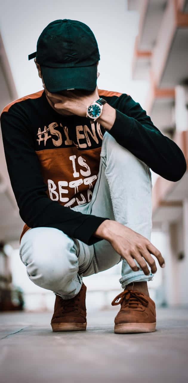 孤獨身影 - 酷帥憂鬱男孩的隱居者 壁紙 — 一個人蹲低，戴著帽子及圖案T恤，手靠近臉部，身處城市小巷。