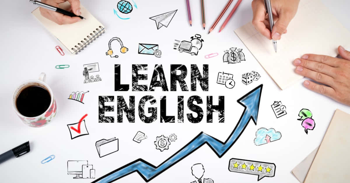 學習英語圖標攝影藝術畫 壁紙 — Overhead view of hands writing around bold 'LEARN ENGLISH' text with upward arrow and educational doodles on white desk.