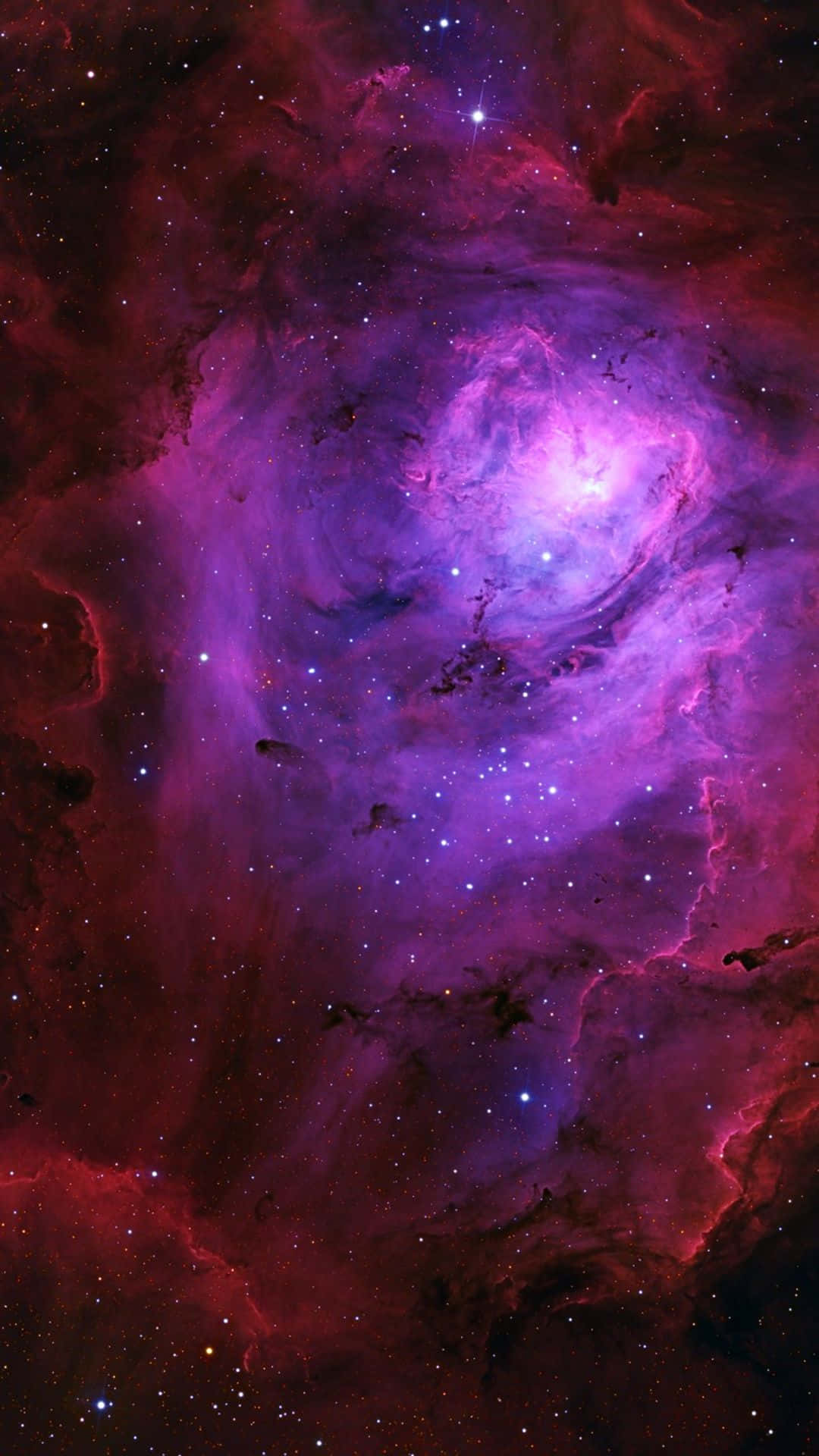 深空中充滿星星的鮮豔紫色和紅色星雲