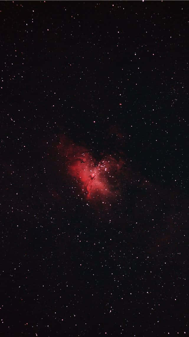 夜空中被無數星星包圍的發光紅色星雲。
