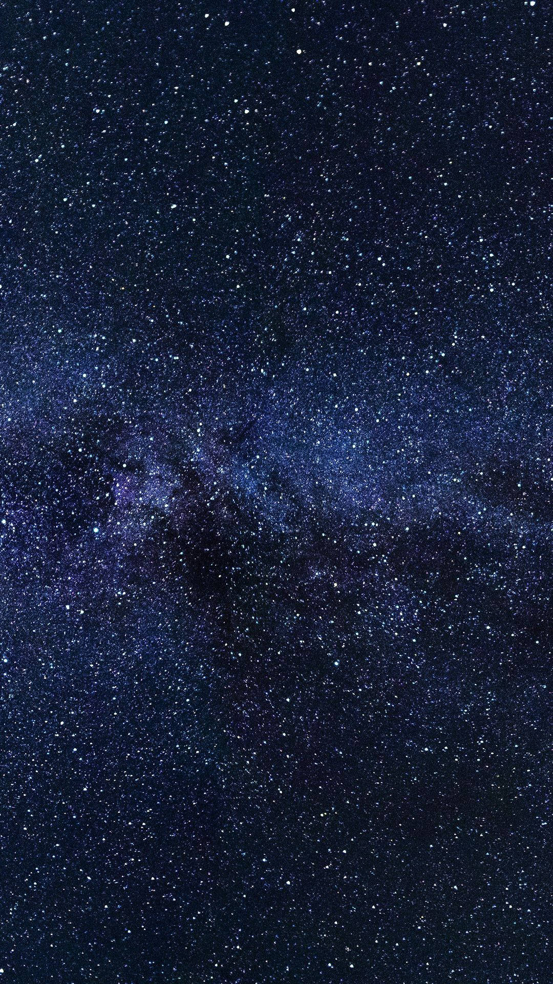 銀河系，在深藍色和紫色的夜空中擁有密集的星場和宇宙塵埃雲。