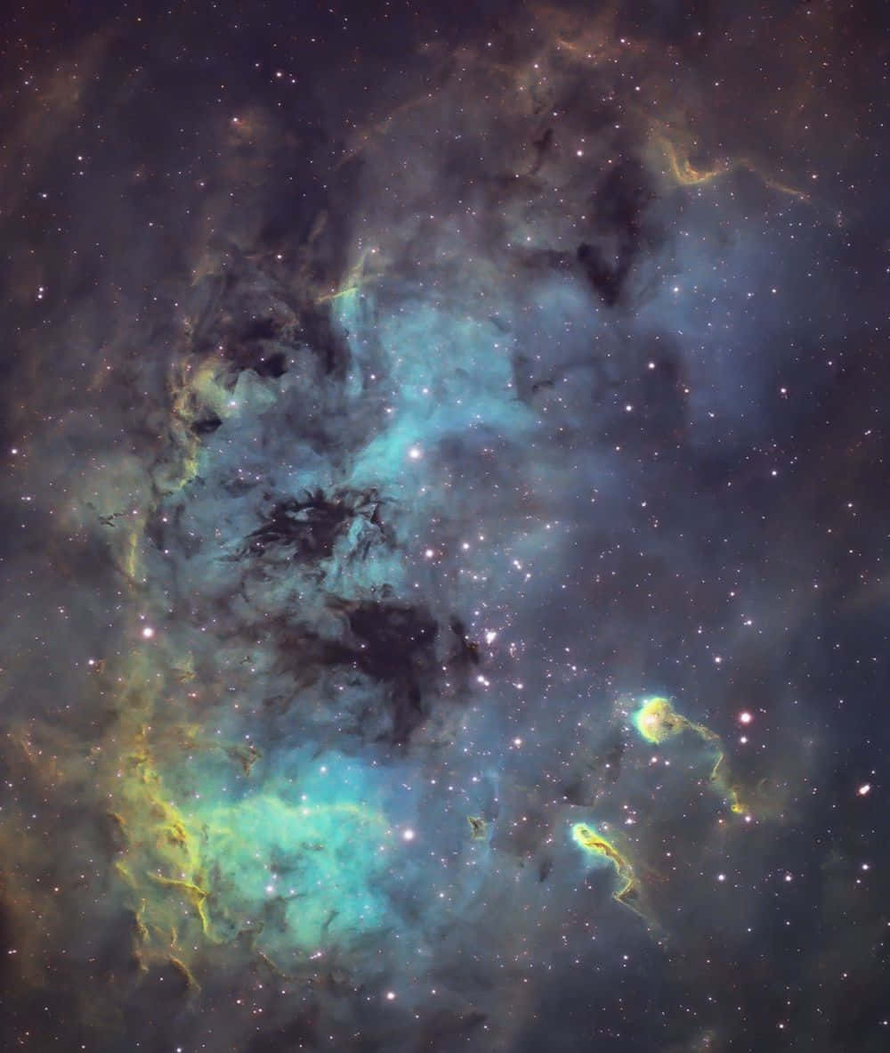 Interstellar Cloud 桌布 壁紙 — 宇宙星雲在星空背景下旋轉，散發著發光的青綠色和金色氣體雲。
