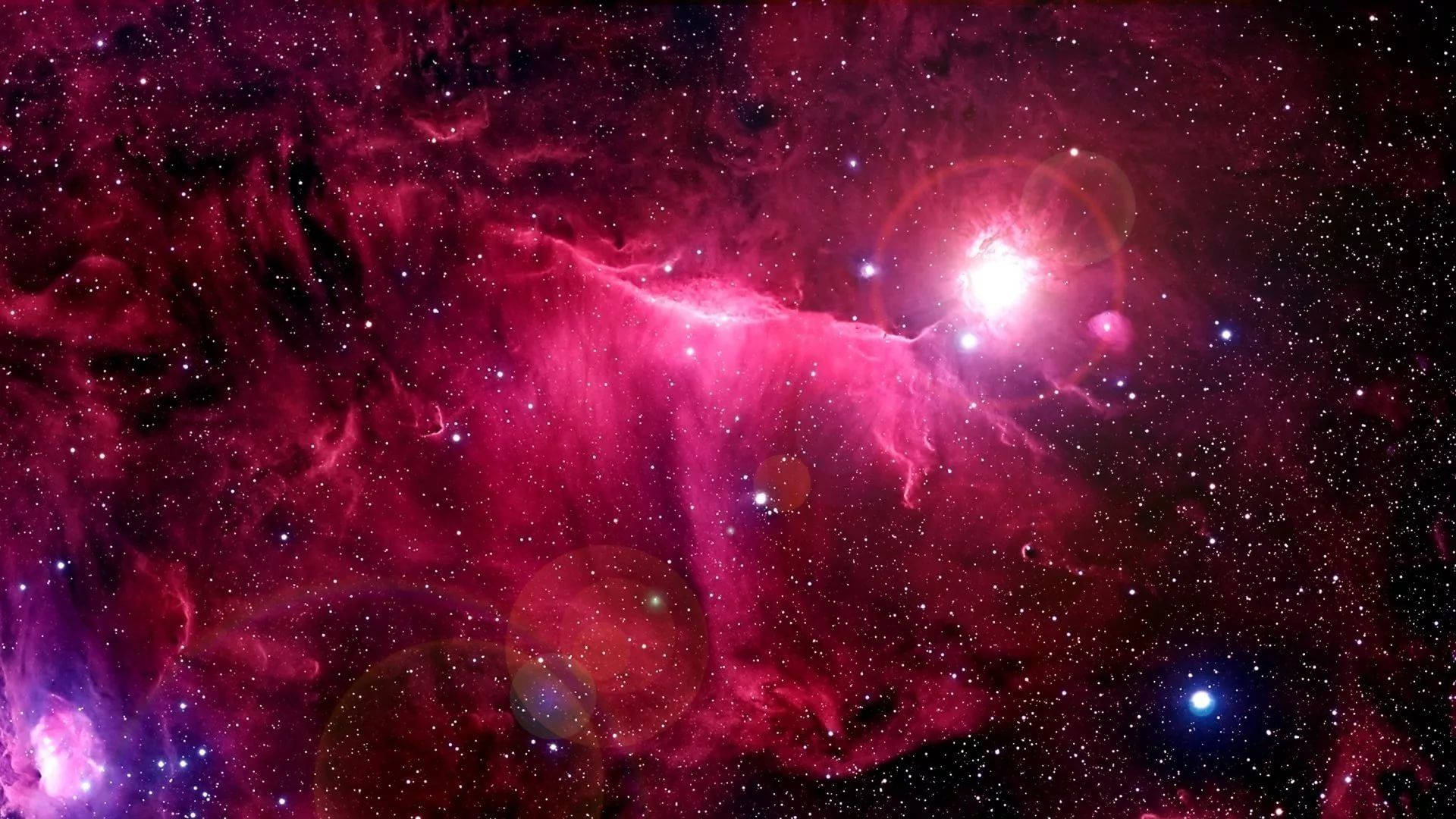 宇宙粉紅星光 壁紙 — 一個充滿活力的宇宙星雲，在星場和鏡頭光暈的襯托下，散發出電光粉紅和紫色的色調。