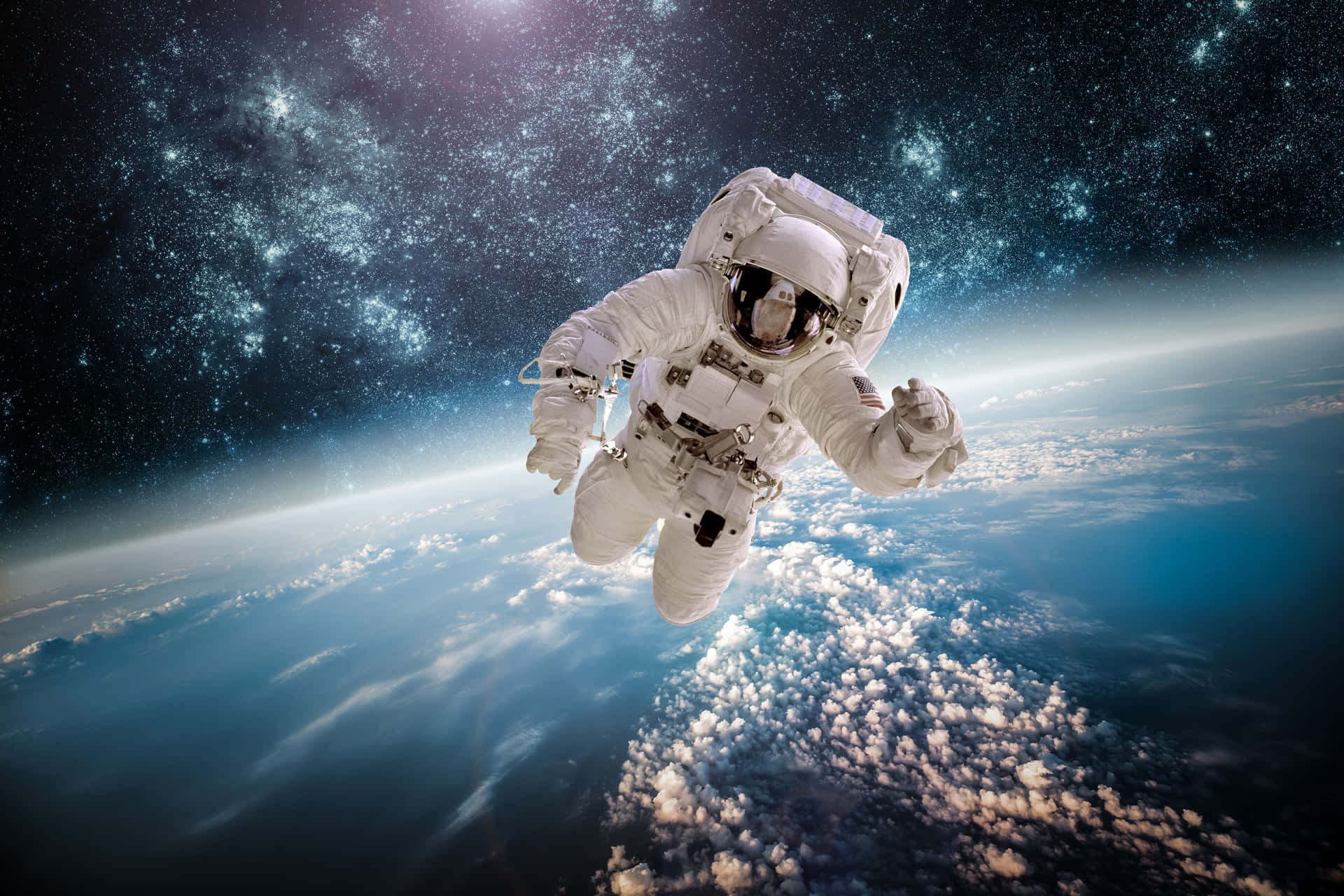 太空人在星空下漂浮於地球的雲層和海洋之上。