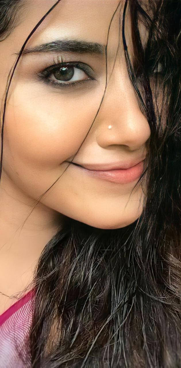 一位深色頭髮、有鼻環的女性對著鏡頭溫柔微笑。