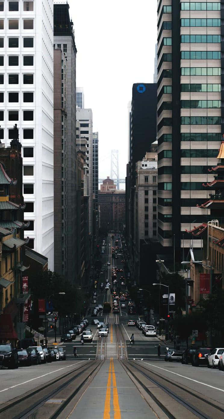 高樓之間有電車軌道的城市街道，通往遠處的橋樑。