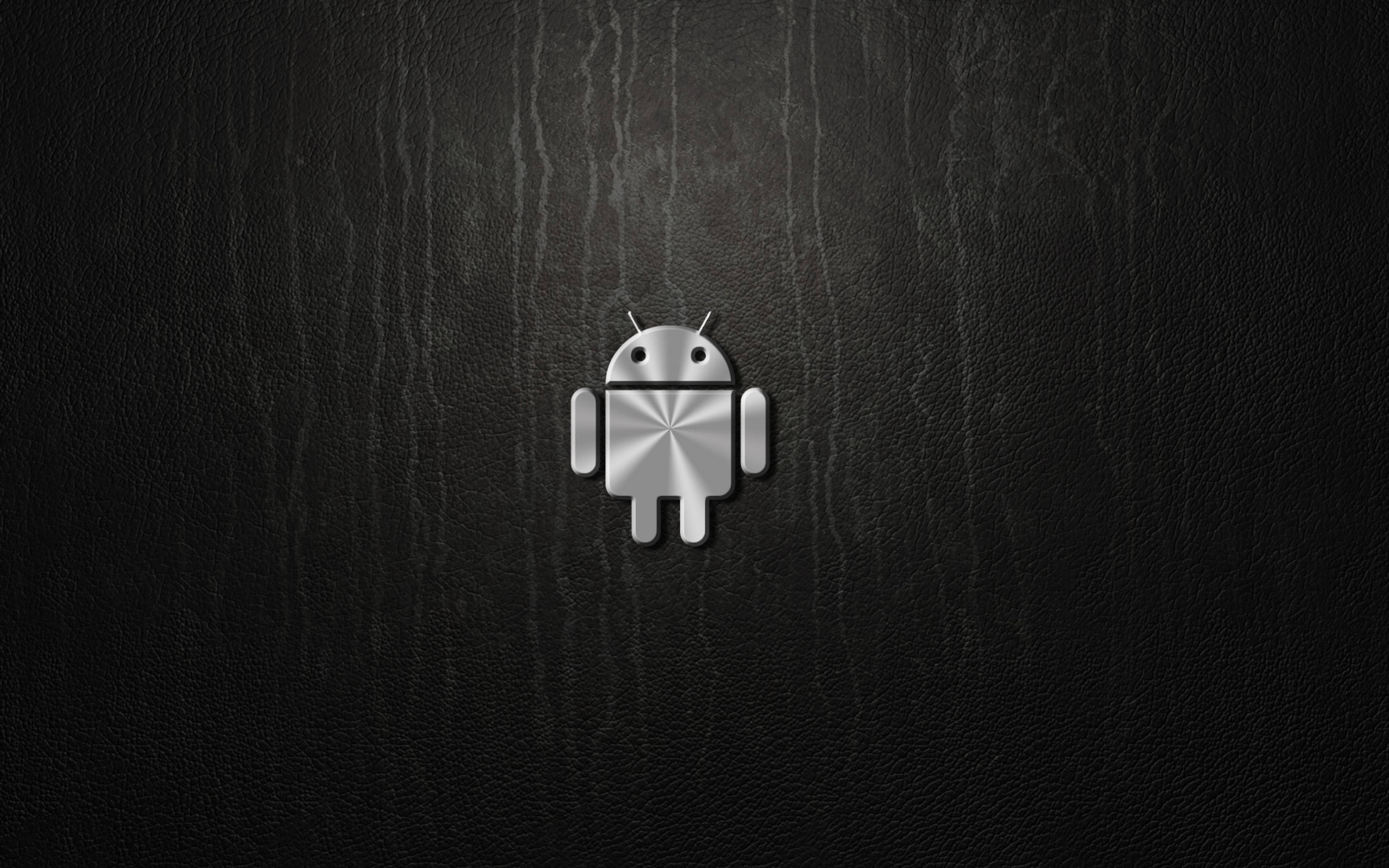 安卓金屬標誌桌面 壁紙 — 閃亮銀色Android機械人標誌居中於帶有細微垂直條紋的紋理黑色皮革背景上。