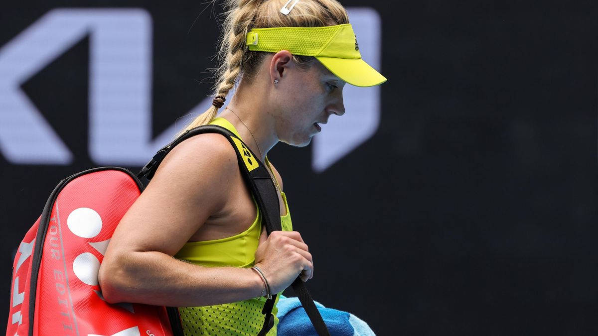 女網球運動員在球場上背著紅色球拍袋
