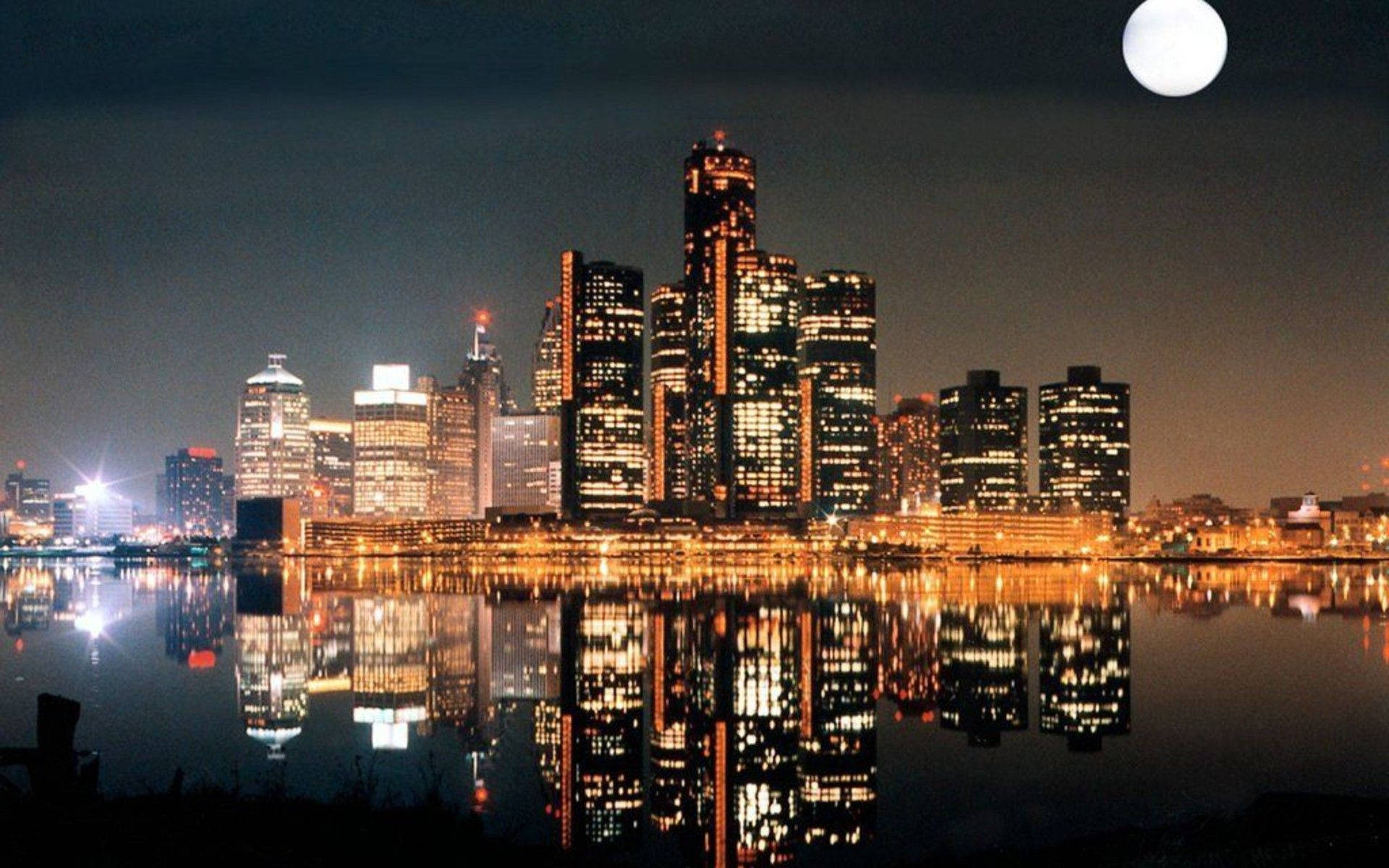 安大略夜景 壁紙 — 明亮的滿月下，充滿活力的城市天際線倒映在平靜的水面上。